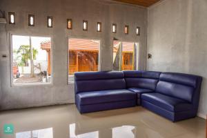a blue couch in a living room with a window at Instay Villa Dieng Kademangan in Wonosobo +20 photos