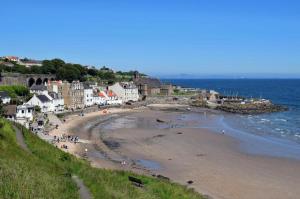 a group of people on a beach near the ocean at 3 Bedroom Flat - Sleeps 6 - Free Parking in Kirkcaldy