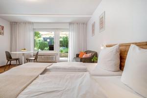 two beds in a white room with a window at Ferienwohnung am Bächler in Hagnau