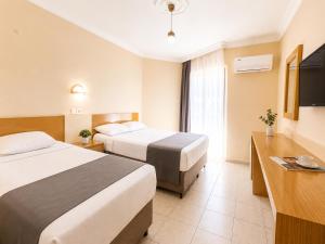 a hotel room with two beds and a television at Yaman Life Hotel in Alanya