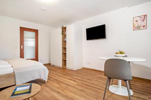a bedroom with a bed and a table and a chair at Ferienwohnung am Bächler in Hagnau