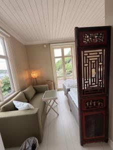 a living room with a couch and a bed and windows at Hem till Bengt in Kungshamn +43 photos