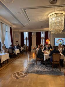 a group of people sitting at tables in a restaurant at Hotel Radmilovac in Belgrade
