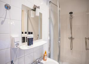 a bathroom with a shower and a toilet and a sink at Hotel Nine in Zandvoort +94 photos