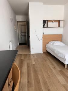 a bedroom with a bed and a desk in a room at KOSY Appart'Hôtels - La Maison Des Chercheurs in Vandoeuvre-lès-Nancy