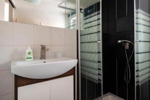 a bathroom with a white sink and a shower at Apartman Borievka in Poprad