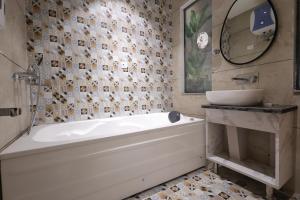 a bathroom with a tub and a sink and a mirror at Hotel Marina in Meerut +53 photos