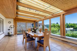 a dining room with a table and chairs and windows at Landzeit in Efringen-Kirchen