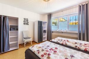 a bedroom with two beds and a window at Landzeit in Efringen-Kirchen