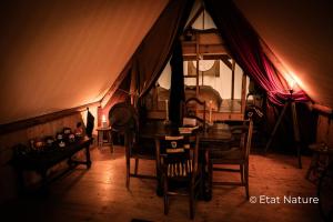 a room with a table and chairs in a tent at Gîte du sorcier - Etat Nature in Magnières