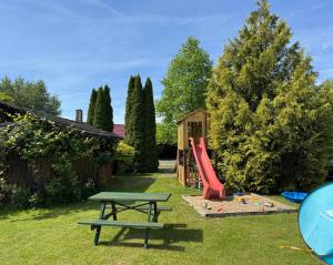 a playground with a red slide and a picnic table at Bokaczówka in Ustka