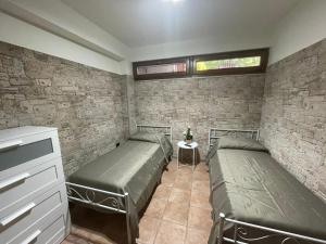 a bedroom with two beds and a brick wall at Il Rifugio nel Matese in San Massimo