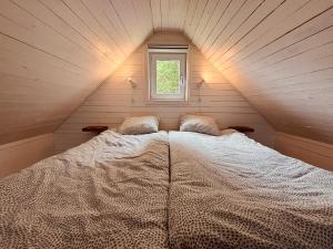 a large bed in a room with a window at Mysig stuga i Haverdal nära strand, hav och naturreservat in Haverdal