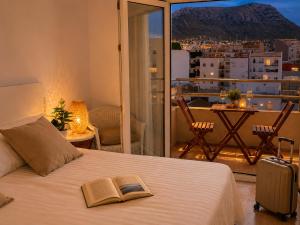 a bedroom with a bed with two books on it at Hostal Comercio in Denia