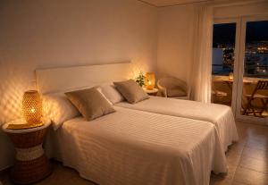 a bedroom with a large white bed with a window at Hostal Comercio in Denia