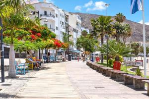 a street with benches and palm trees and buildings at Hortensia Suites Apartments, Los Cristianos, Tenerife in Los Cristianos