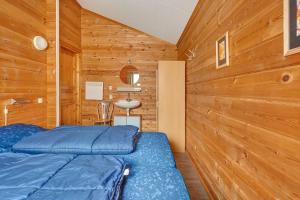 a bedroom with two beds and a wooden wall at Fins Chalet op vakantiepark in Gramsbergen +54 photos