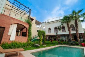 an exterior view of a house with a swimming pool at Riad Saida Atlas in Marrakesh