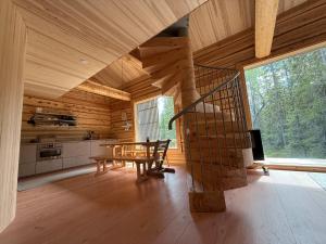 a room with a staircase and a table in a cabin at Handcrafted Log Chalet Villa Aarreaitta in Syöte +25 photos