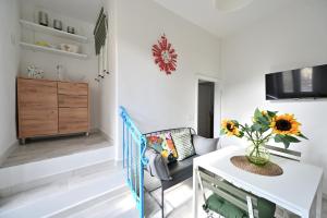 a living room with a white table with a vase of flowers at Little Cozy House in Loro Ciuffenna