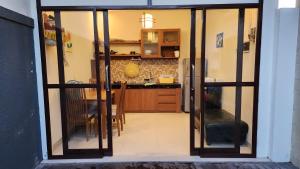 a kitchen with sliding glass doors and a dining room at Pondok Ashanara Sading in Sempidi