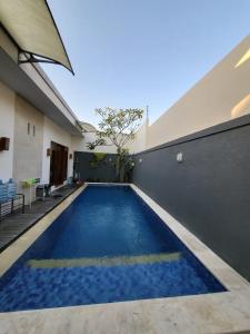 an indoor swimming pool with blue water in a building at Pondok Ashanara Sading in Sempidi +1 photo