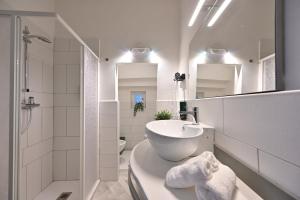 a white bathroom with a sink and a toilet at Little Cozy House in Loro Ciuffenna