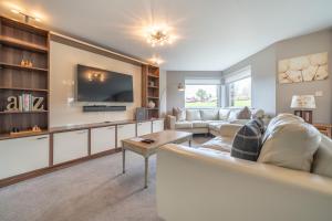 a living room with a couch and a tv at Golf Apartment @ Carus Green in Kendal