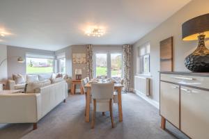 a kitchen and living room with a table and a couch at Golf Apartment @ Carus Green in Kendal