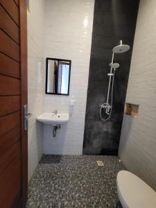 a bathroom with a sink and a toilet at Pondok Ashanara Sading in Sempidi