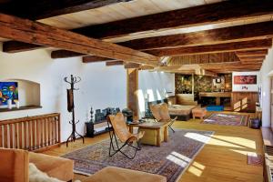 a living room with wooden ceilings and a living room with chairs at Zalanka in Zalaköveskút