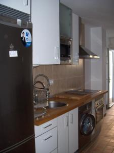 a kitchen with a sink and a black refrigerator at Apartamento Caballo Sherry in El Puerto de Santa María