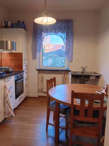 a kitchen with a table and chairs and a window at Honeymoon Guesthouse in Helsingborg