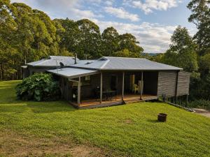 a house with a large yard in front of it at Thrums Bush Retreat in Upper Orara