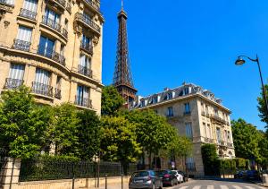 a view of the eiffel tower between two buildings at Eiffel Tower spacious 2-bedroom, 2-bathroom quiet apartment, elegant and peaceful in Paris