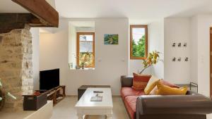 a living room with a couch and a tv at Gîte La Longère in Laillé