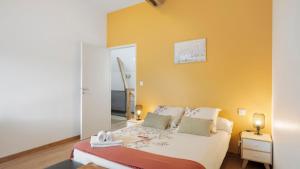 a bedroom with a bed and a yellow wall at Gîte La Longère in Laillé