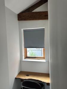 a window in a room with a desk and chairs at The Upper Nest in Hereford +6 photos