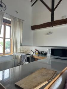 a kitchen with a counter with a cutting board on it at The Upper Nest in Hereford