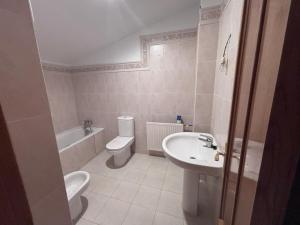 a bathroom with a toilet and a sink and a tub at Casa Familiar Mazalvete in Mazalvete