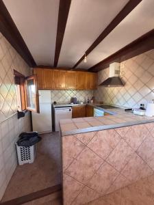 a kitchen with wooden cabinets and a counter top at Casa Familiar Mazalvete in Mazalvete