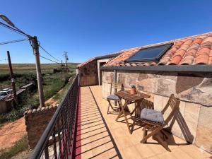 a patio with a table and chairs on a balcony at Casa Familiar Mazalvete in Mazalvete