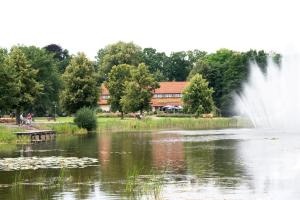 a pond with a fountain in front of a building at Hotel und Restaurant Röbler Thor in Wittstock