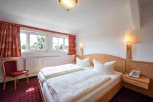 a hotel room with a large bed and a red chair at Hotel und Restaurant Röbler Thor in Wittstock