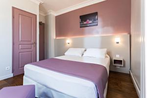 a bedroom with a large bed with a pink wall at Modern Hotel in Paris