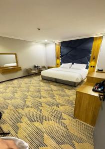 a bedroom with a bed with a large headboard at زون آفينيو للشقق المخدومة Zone avenue in Hafr Al-Batin