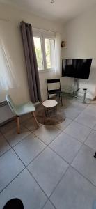 a living room with a chair and a tv at Maisonette bedogao in Valence