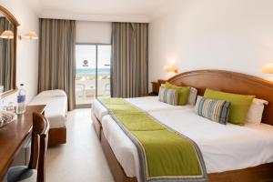 a hotel room with a bed and a desk and a window at Yadis Hammamet in Hammamet +85 photos