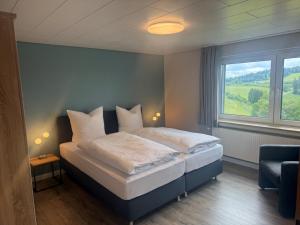 a bedroom with a large bed with a window at Pension Haus Astenblick in Winterberg
