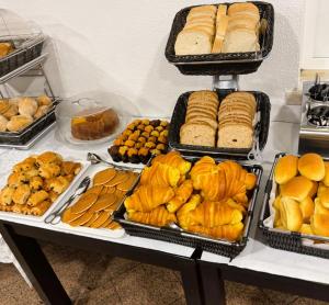 a table filled with trays of bread and pastries at B&B Berlenga 4 in Nazaré
